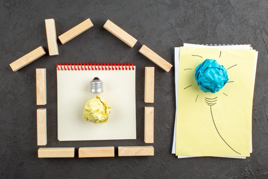 A light bulb and crumpled paper on a black background, representing innovative ideas for home renovation projects